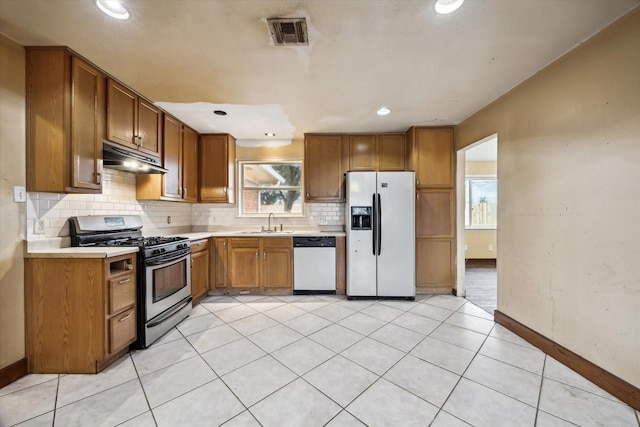 kitchen featuring under cabinet range hood, stainless steel appliances, a sink, visible vents, and light countertops