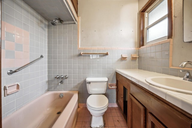 bathroom with bathtub / shower combination, toilet, vanity, tile walls, and tile patterned floors