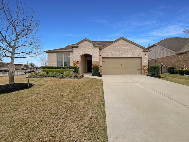 view of front of home featuring brick siding, an attached garage, a front yard, fence, and driveway