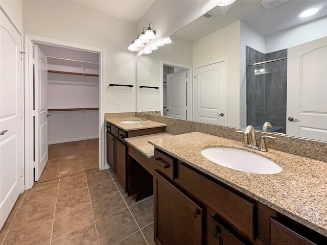 full bath with a shower stall, visible vents, a walk in closet, and a sink