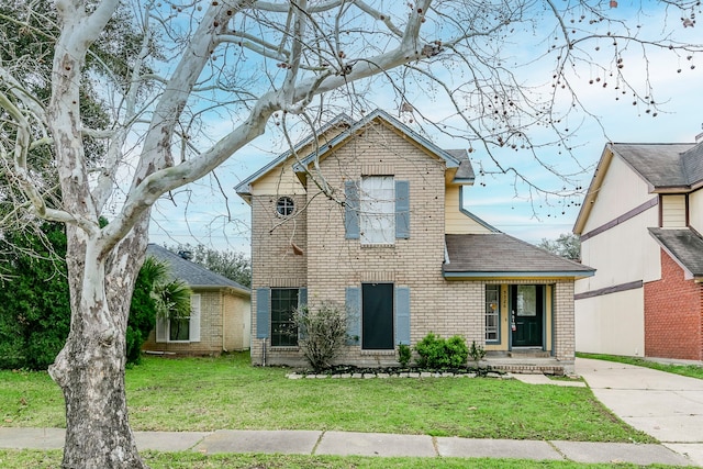 traditional home with brick siding, a front lawn, and roof with shingles