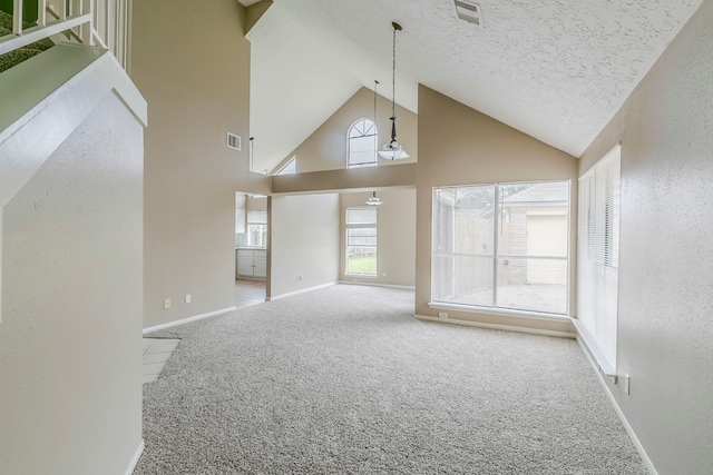 unfurnished living room featuring carpet floors, high vaulted ceiling, visible vents, and a textured ceiling