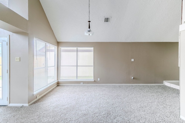 unfurnished room featuring lofted ceiling, visible vents, carpet flooring, and a textured ceiling