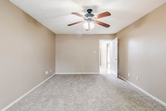 carpeted spare room featuring a textured ceiling, a ceiling fan, and baseboards