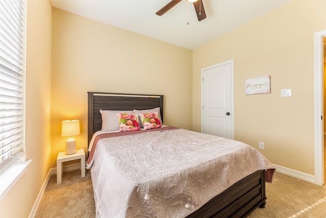 bedroom featuring a ceiling fan, light carpet, and baseboards