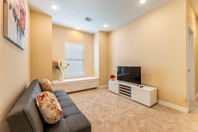 living area with light carpet, baseboards, and visible vents