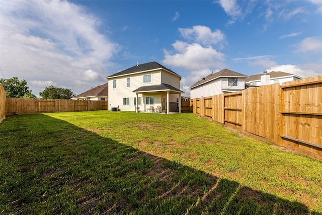 rear view of property with a fenced backyard and a lawn