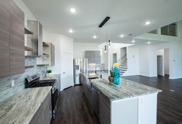 kitchen featuring light stone counters, decorative light fixtures, open shelves, stainless steel appliances, and a sink