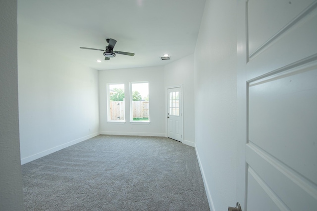 empty room featuring baseboards, visible vents, ceiling fan, and light colored carpet