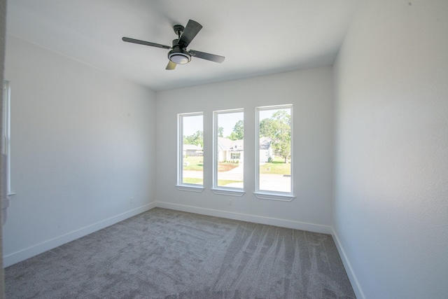 empty room featuring a ceiling fan, baseboards, and carpet flooring