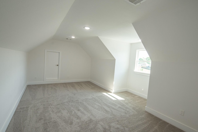 additional living space with lofted ceiling, light colored carpet, baseboards, and recessed lighting