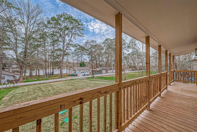 wooden deck with a residential view, covered porch, and a yard