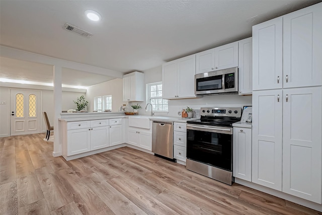 kitchen featuring visible vents, appliances with stainless steel finishes, light countertops, and a sink