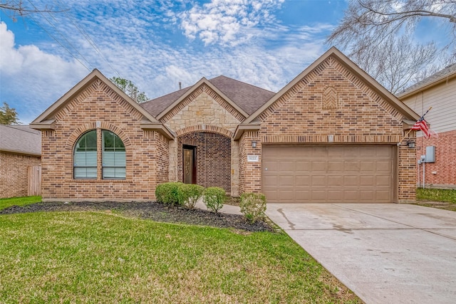 french country style house with a garage, driveway, a front yard, and brick siding