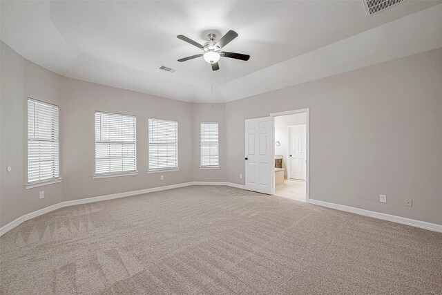 spare room with visible vents, light carpet, and baseboards