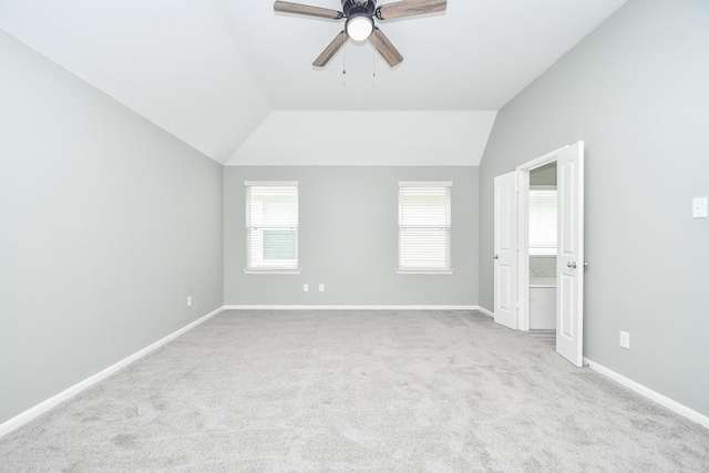 unfurnished room featuring vaulted ceiling, ceiling fan, light carpet, and baseboards