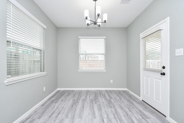 unfurnished dining area featuring a healthy amount of sunlight, light wood-style flooring, and baseboards