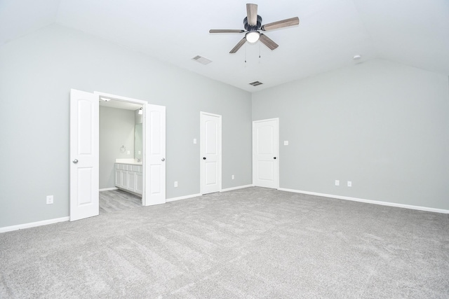 unfurnished bedroom with lofted ceiling, baseboards, visible vents, and light colored carpet