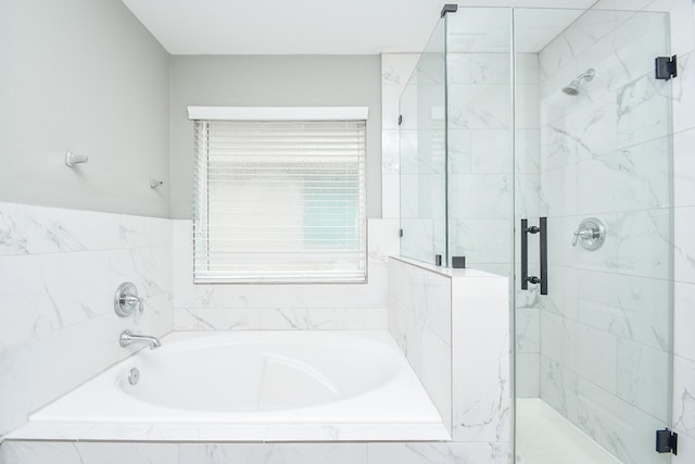 full bathroom with a shower stall and a bath