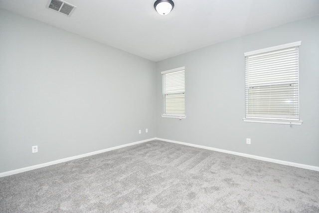 spare room featuring carpet, baseboards, and visible vents