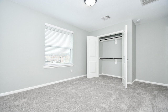 unfurnished bedroom featuring light carpet, a closet, visible vents, and baseboards