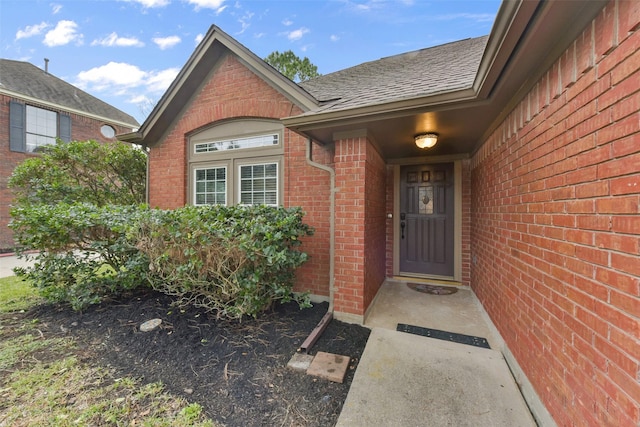 entrance to property with brick siding and roof with shingles