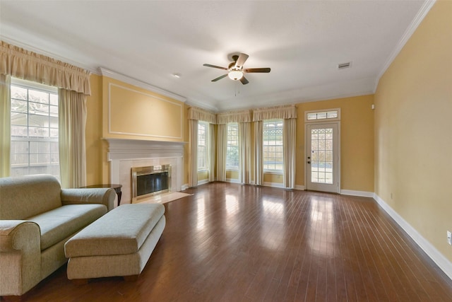 living room with a wealth of natural light, crown molding, and wood finished floors