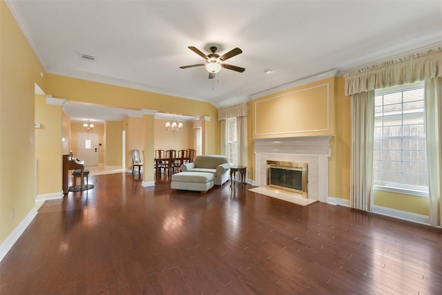 unfurnished living room with a tile fireplace, dark wood-style flooring, visible vents, baseboards, and ornamental molding