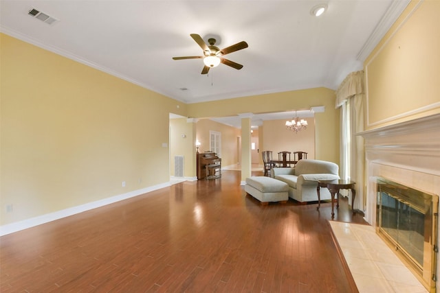 living area featuring ornamental molding, a tile fireplace, wood finished floors, and visible vents