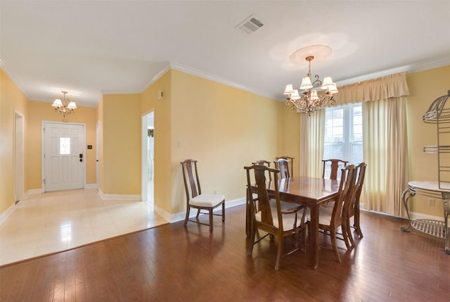 dining area with light wood-style flooring, visible vents, and an inviting chandelier