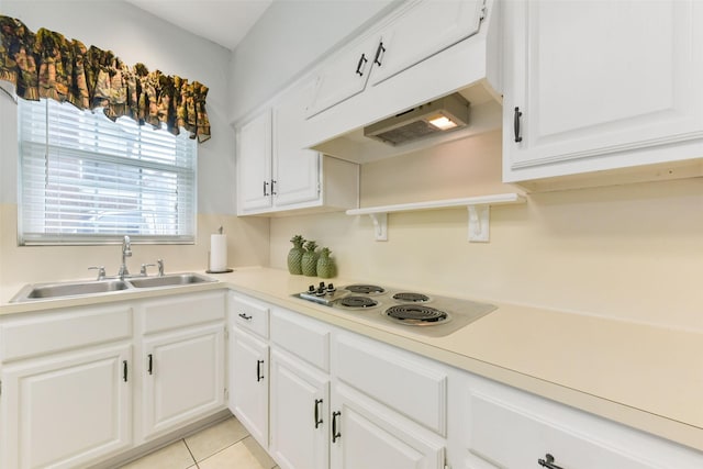 kitchen featuring cooktop, light countertops, white cabinetry, a sink, and light tile patterned flooring