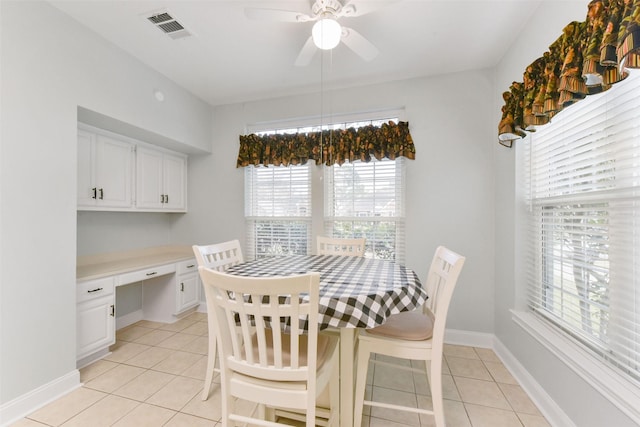 dining room featuring built in desk, light tile patterned floors, visible vents, ceiling fan, and baseboards