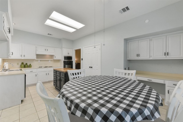 dining room with light tile patterned flooring, built in study area, and visible vents