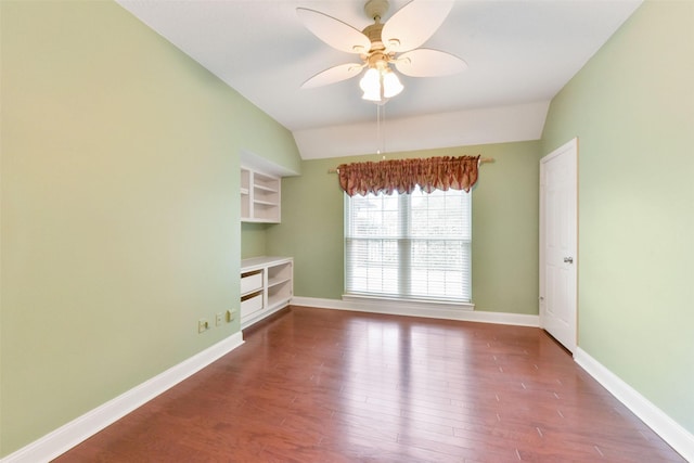 unfurnished room with built in features, a ceiling fan, vaulted ceiling, wood finished floors, and baseboards