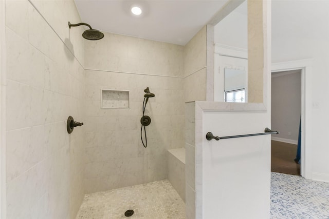 bathroom featuring baseboards and a tile shower