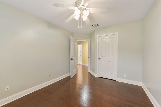 unfurnished bedroom featuring dark wood-type flooring, a ceiling fan, visible vents, and baseboards