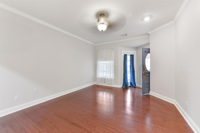 spare room featuring crown molding, baseboards, dark wood finished floors, and a ceiling fan