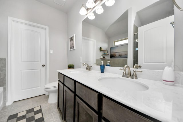 bathroom with toilet, double vanity, vaulted ceiling, and a sink