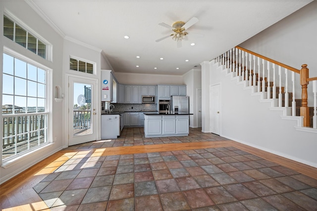 kitchen featuring stainless steel appliances, a sink, baseboards, decorative backsplash, and dark countertops