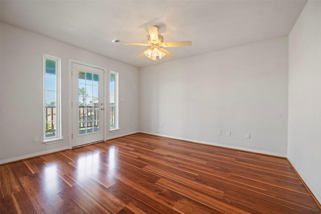 spare room featuring ceiling fan, dark wood-type flooring, and baseboards