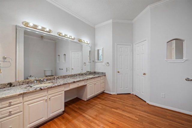 full bath with toilet, a sink, ornamental molding, a closet, and double vanity