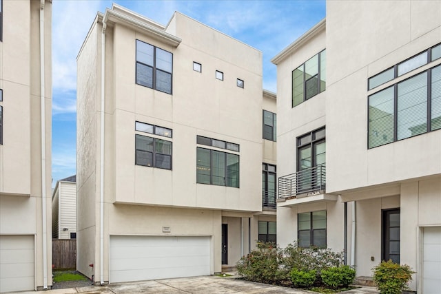 view of front of house featuring an attached garage, concrete driveway, and stucco siding