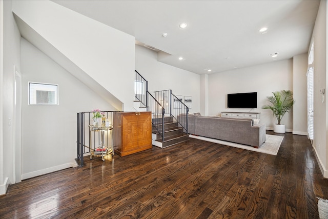 living room with stairs, baseboards, dark wood-type flooring, and recessed lighting