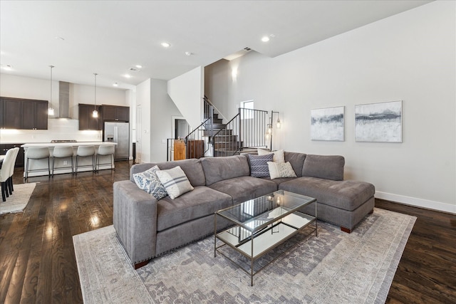 living area featuring dark wood-style floors, stairs, baseboards, and recessed lighting