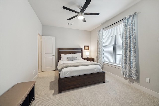 bedroom featuring ceiling fan, light colored carpet, visible vents, and baseboards