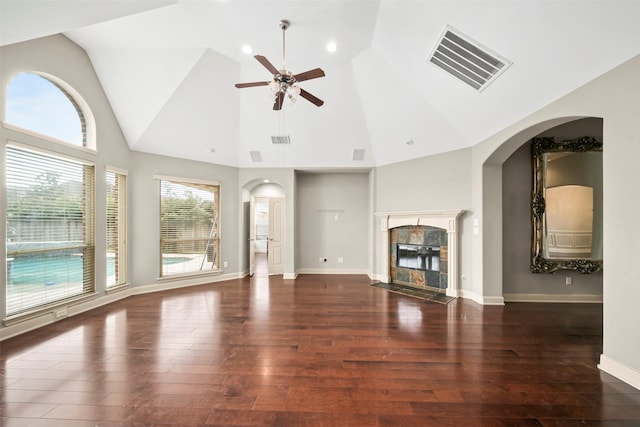 unfurnished living room with ceiling fan, dark wood-type flooring, a fireplace, visible vents, and baseboards