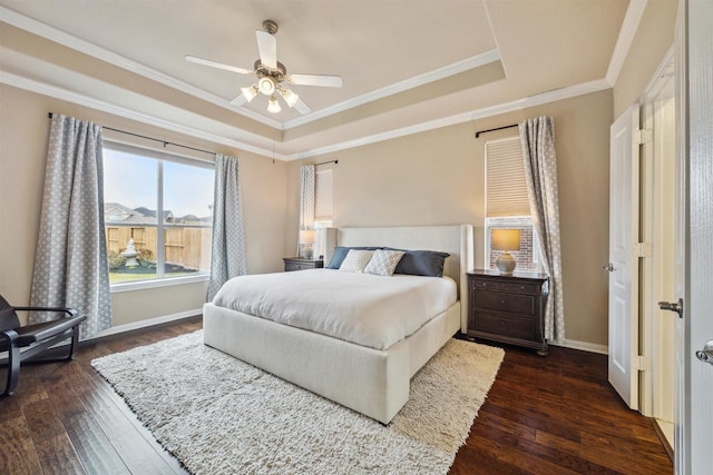 bedroom with a raised ceiling, baseboards, crown molding, and dark wood-style flooring