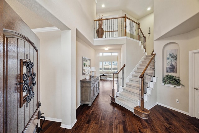 foyer entrance featuring recessed lighting, stairway, a high ceiling, dark wood-type flooring, and baseboards