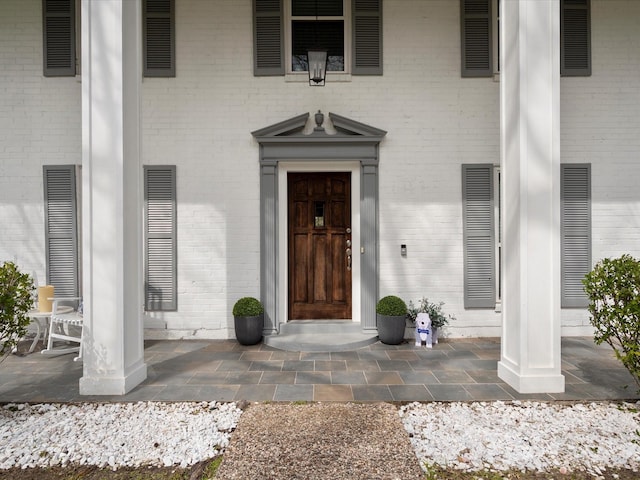 doorway to property with brick siding