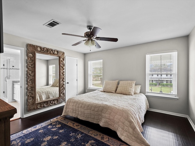 bedroom featuring visible vents, wood finished floors, connected bathroom, baseboards, and ceiling fan